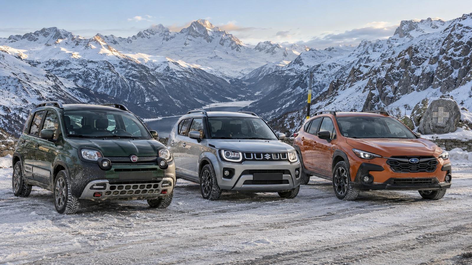 Fiat Panda Cross, Suzuki Ignis und Subaru Crosstrek stehen auf einem verschneiten Schweizer Alpenpass nebeneinander.